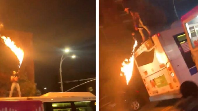 Guy Stands On Top Of A Bus With A Flamethrower And Fires Away